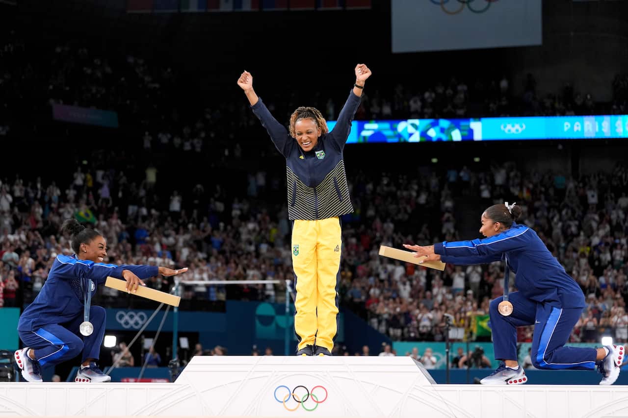 Two women bow down to another woman who won the gold medal
