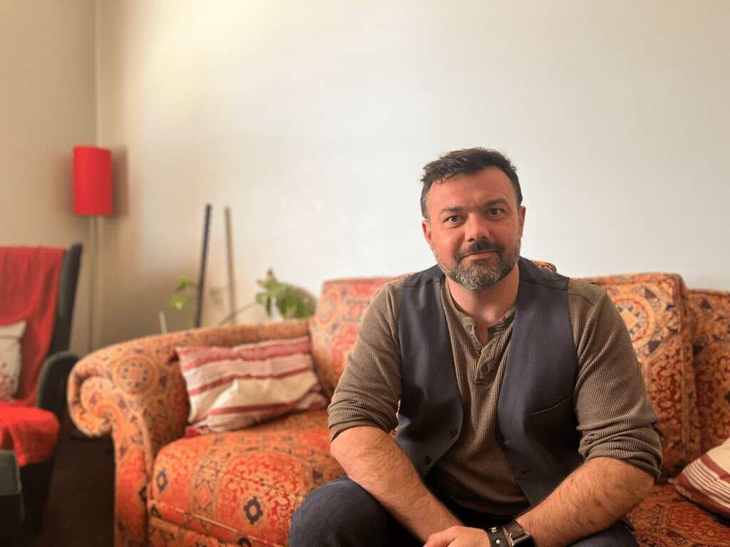 Paul Benson sitting in his home.