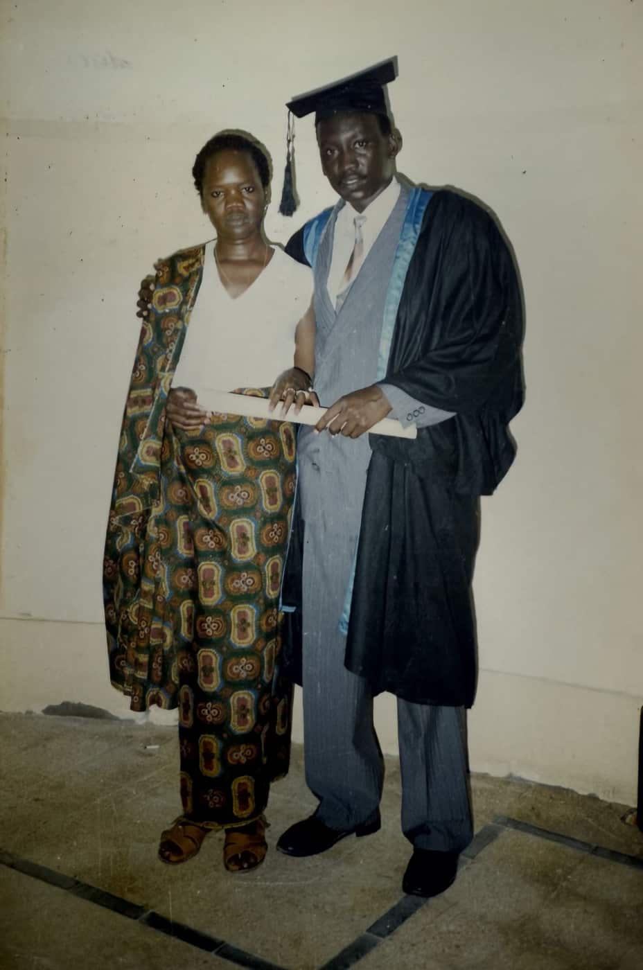 A man next to a woman at his university graduation.