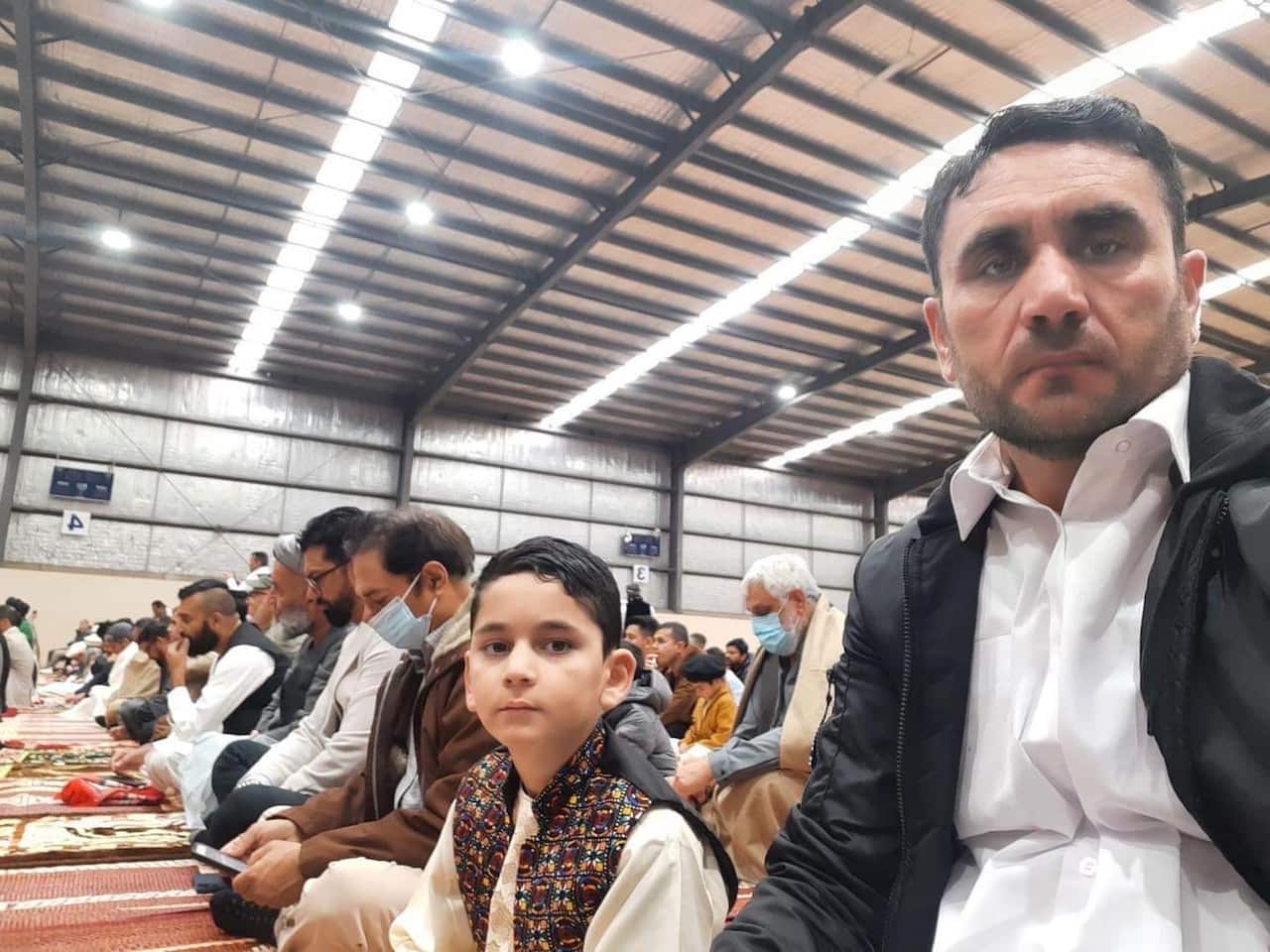 Sayed Wahdat Saddat with his son at Eid prayers in Melbourne.