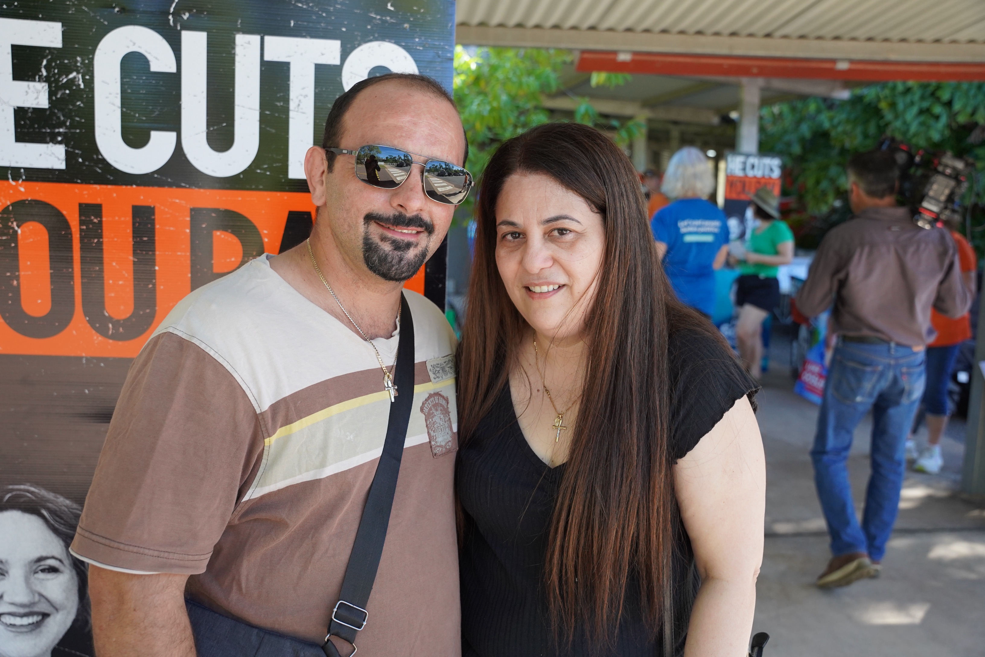 A man and woman standing together in front of a polling centre.